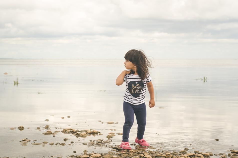 Young girl, on the beautiful of the beautiful lake, under the cloudy sky