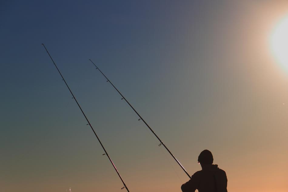 silhouette of a fisherman against the background of the sun