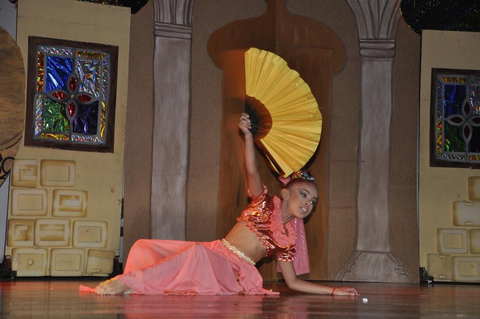 Girl, in the beautiful and colorful, Arabic costume, dancing, with the colorful and beautiful fan in the theatre
