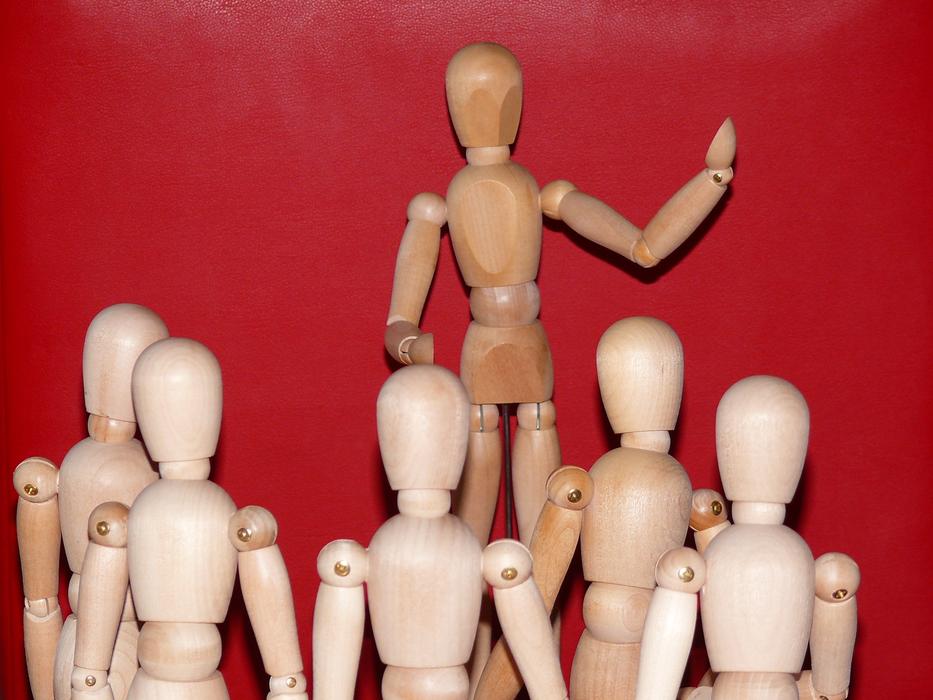 Wooden figures on the lecture at red background