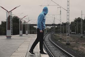 a man waiting for a train on a railway platform