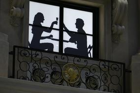 silhouette of a couple at a table on a balcony in Macau, China