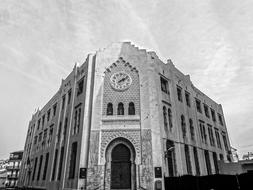 black and white photo of a building with a big clock in Algeria