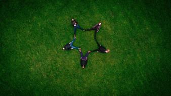 five pointed star formed by people laying on grass
