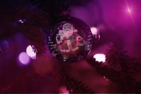 santa claus drawing on christmas ball, purple background