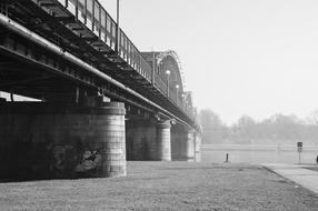 black and white photo of a railway bridge over a river