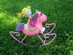 Colorful and cute, shiny toy, with the girl on the horse, on the green grass