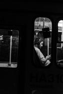 view of man in headphones through Window of train