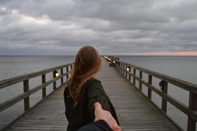 young Girl on pier at stormy evening