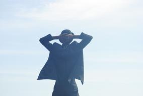 the silhouette of a man by the clouds and the sun