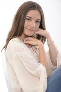 photo of pretty girl in white clothing with hands near face