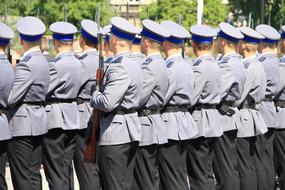 Uniformed young men with rifles standing in rows