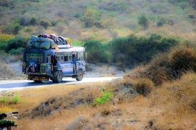 old painted bus with load on roof on road in wilderness, Madagascar