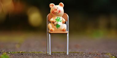 porcelain pig is sitting on a chair
