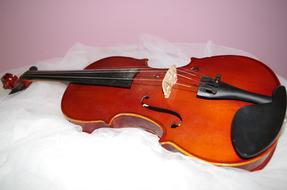 Violin laying on white tissue