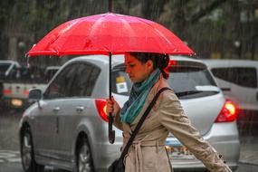 woman under a red umbrella on a city street