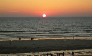 the sun burning over the sea