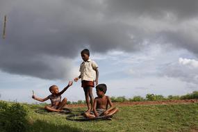 Childhood, three dark skin child Boys plays on lawn