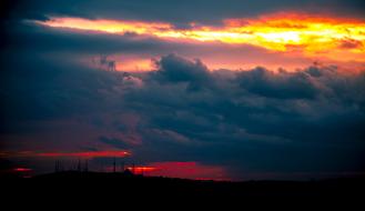 dark clouds at sunset sky over distant city