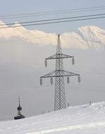 pole with power lines on a hill in winter