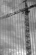 black and white reflection of a construction crane through the windows of a skyscraper