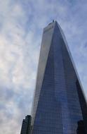 Beautiful One World Trade Center in Manhattan, New York, USA, at blue sky with white clouds on background