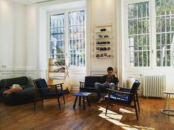 man reading in vintage interior at lattice window