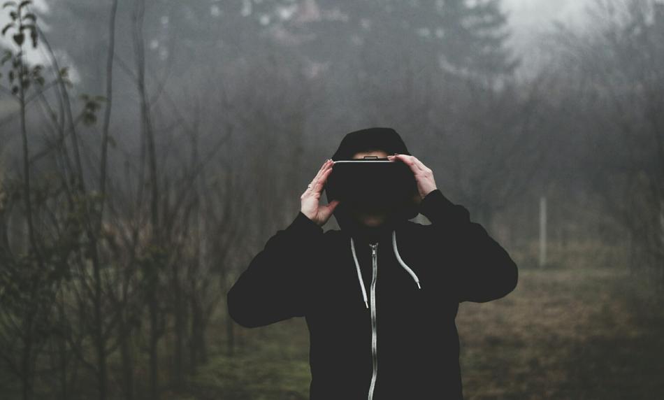 Boy in black Vr Goggles, among the plants and fields in fog