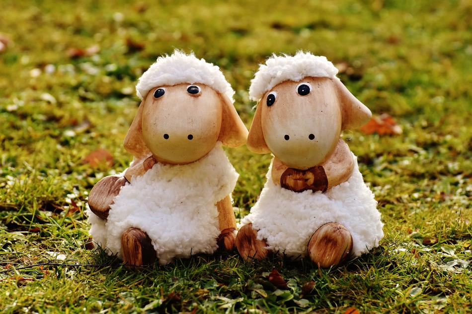 two porcelain sheep on a green lawn