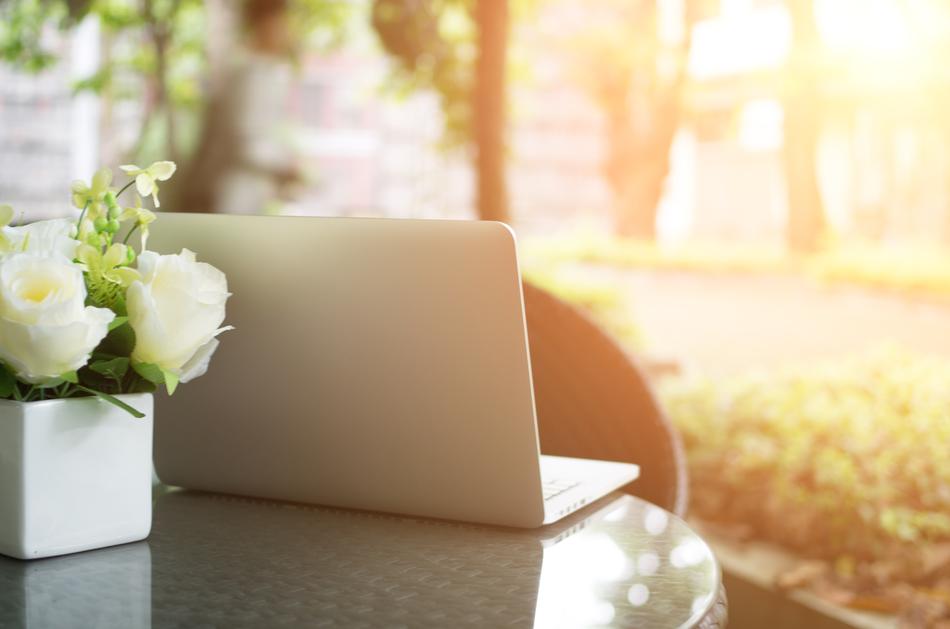 laptop and roses in a vase on the table
