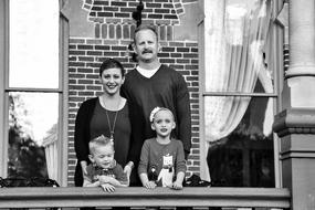 black and white, family standing by the window
