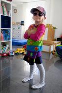 funny child Girl in dark glasses and cap indoor