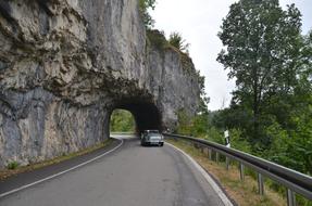 car drives through a stone archway