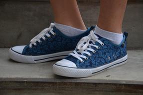 photo of the girl's legs in blue sneakers