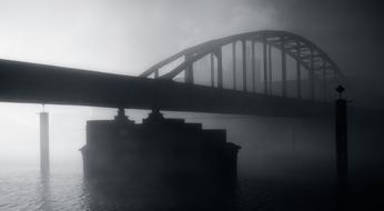 Black and white bridge above the water in fog