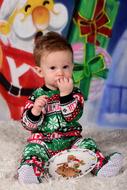 Child boy eating cookies on floor at Christmas decorations