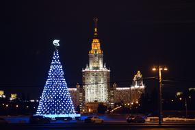 brightly lit christmas tree outside the city building