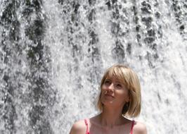 portrait of Beautiful Girl at the background of Waterfall