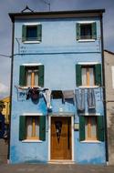 clothes are dried on a rope on the facade of a building on the island of Burano in Italy