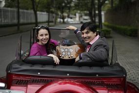 a beautiful couple in a red car