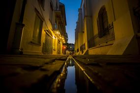 water in a gutter on a narrow street
