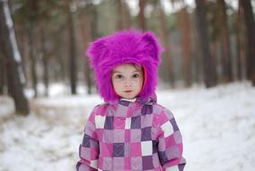 winter photo of a girl in a purple fur hat