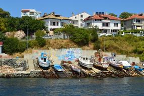 old boats in harbor by wall with graffiti