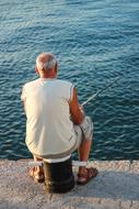 old man fishing from the pier