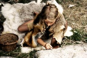 child Girl sits on Animal Skin Rug