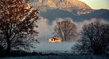 House in Fog in front of mountains at winter