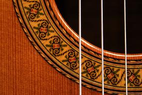 close up of the strings of a wooden guitar
