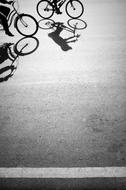 Shadows of Persons riding bikes on road