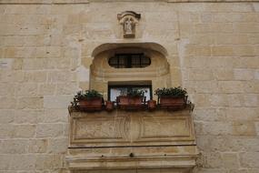 potted flowers at Window on stone Balcony, malta