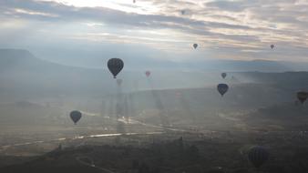 an unusual landscape of balloons over the mountains